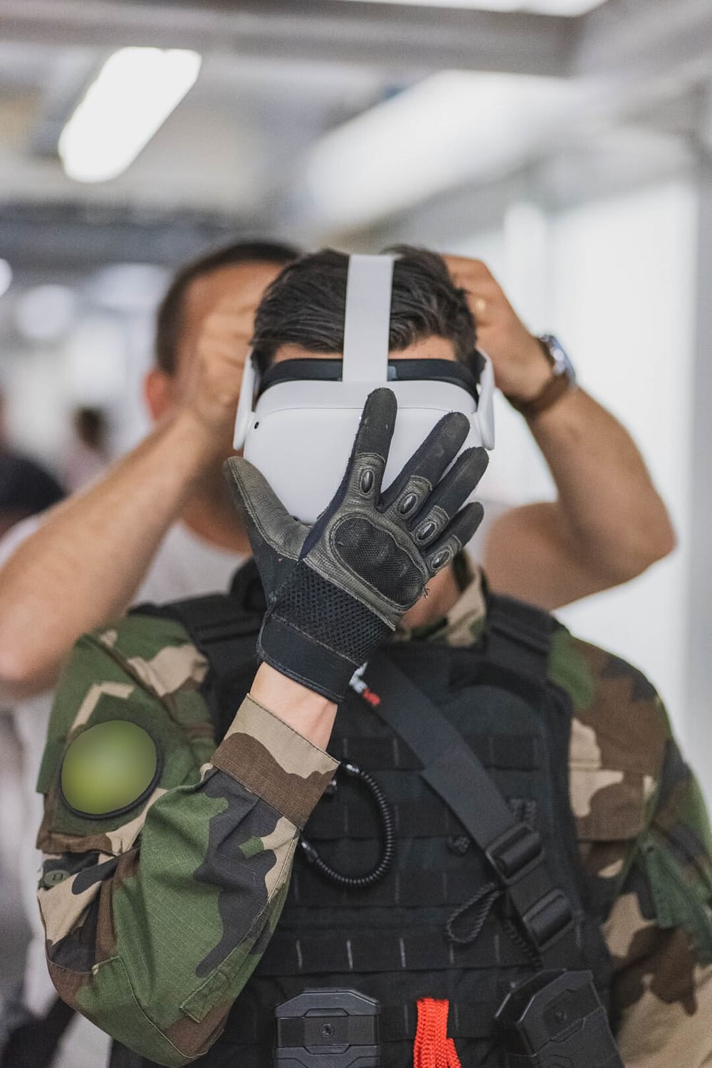 Un soldat en tenue de combat s'équipe d'un casque de réalité virtuelle Meta Quest 2 avec un équipement ProTubeVR